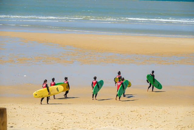 des personnes se dirigent vers la mer avec leur surf à Lacanau